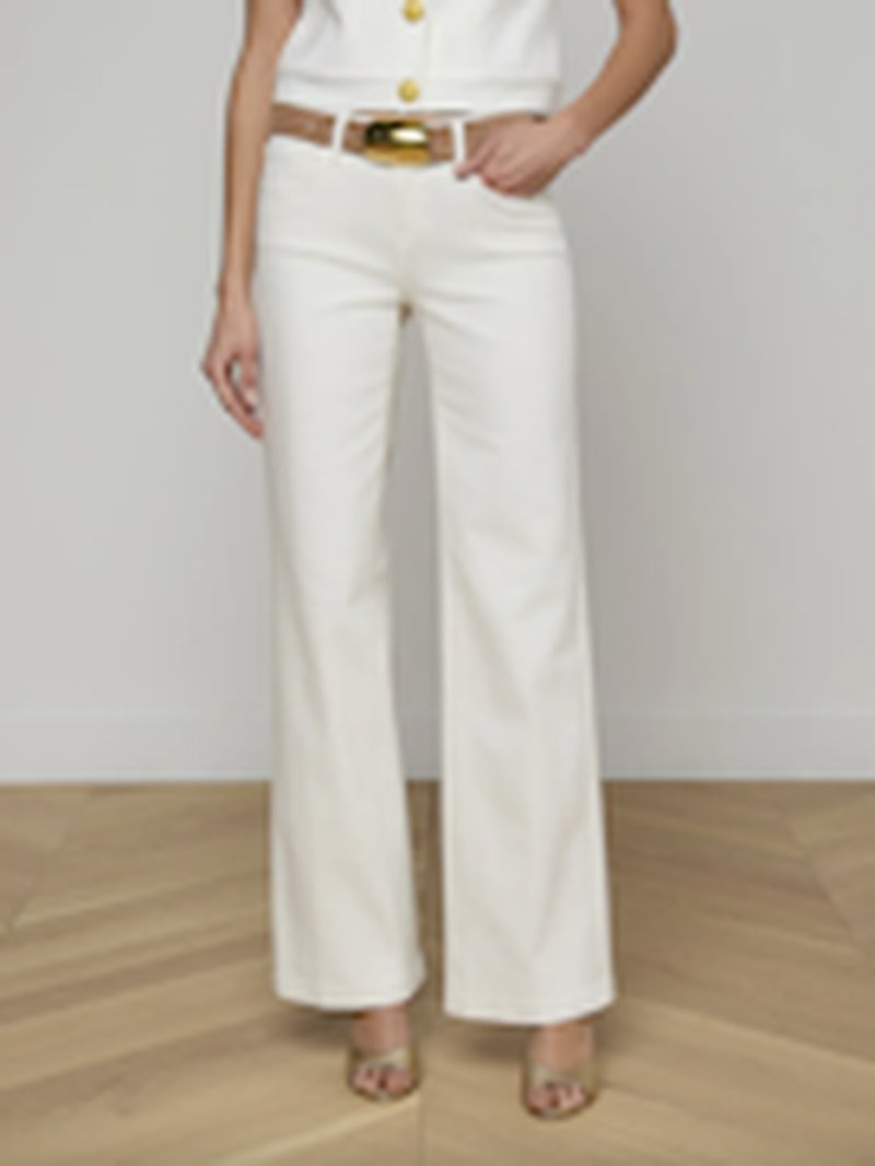 L'Agence Joanne Wide Leg Pant in light ecru, featuring a high-waisted cut, relaxed wide-leg silhouette, and gold-toned waistband hardware, shown on model with coordinating white button-front top